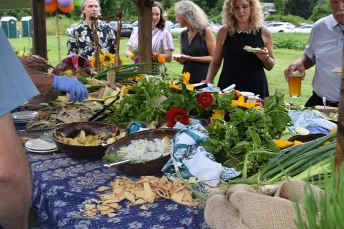 people with plates at an outdoor buffet table